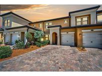 Townhome with two-car garage and brick paver driveway at 10055 Crooked Creek Dr # 102, Venice, FL 34293