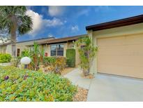 Condo's entrance with walkway and nicely landscaped surroundings at 1211 Capri Isles Blvd # 174, Venice, FL 34292