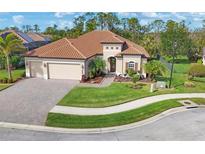 Single-Gathering home with tile roof, landscaping, and driveway at 20909 Duomo Ct, Venice, FL 34293