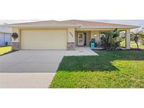 Well-maintained single-story home with a spacious driveway and landscaped lawn at 9325 Crugar Ter, Englewood, FL 34224