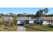 Single-story home with gray roof, stone accents, and a paved driveway at 1040 Hope St, Venice, FL 34285