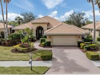 Single-story home with tile roof, landscaping, and paver driveway at 114 Medici Ter, North Venice, FL 34275