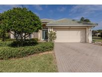 Single-story home with a two-car garage and landscaped front yard at 11584 Dancing River Dr, Venice, FL 34292