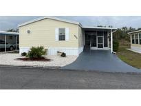 Mobile home with landscaped yard and screened porch at 223 Roma Rd, Venice, FL 34285