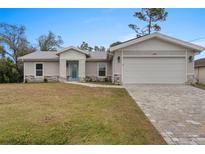 Newly constructed home with a modern design, featuring a paved driveway and attached garage at 2580 Sheila Ln, North Port, FL 34286