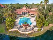 Aerial view of community pool with clubhouse and lush landscaping at 4110 Central Sarasota Pkwy # 127, Sarasota, FL 34238