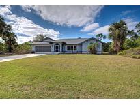 Single-story home with gray roof, screened porch, and large yard at 419 Ramblewood St, Port Charlotte, FL 33953