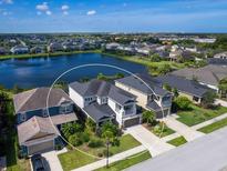 Aerial view of two-story house near lake with neighborhood in background at 5930 Anise Dr, Sarasota, FL 34238