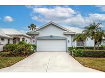 White house with gray accents, two-car garage, and landscaped yard at 655 Crossfield Cir # 7, Venice, FL 34293