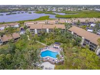 Aerial view of condo community with pool and lush landscaping at 832 Bird Bay Way # 113, Venice, FL 34285