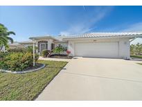 White single-story home with tile roof, two-car garage, and landscaped front yard at 855 Morgan Towne Way, Venice, FL 34292