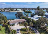 Aerial view of waterfront home with circular driveway, offering peaceful water views at 107 Louella Ln, Nokomis, FL 34275
