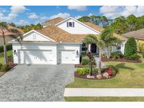 White two-story house with a gray brick driveway and palm trees at 11678 Aucilla Dr, Venice, FL 34293
