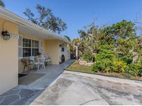 Ranch-style home with a covered patio, mature landscaping, and a spacious driveway at 1300 Indus Rd, Venice, FL 34293
