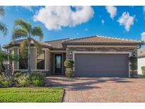 Single-story home with stone accents, tile roof, and two-car garage at 13164 Rinella St, Venice, FL 34293
