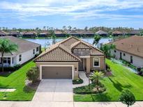 Single-Gathering home with tile roof and a two-car garage, situated on a lake at 1675 Still River Dr, Venice, FL 34293