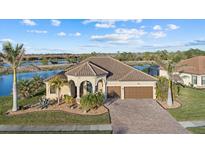 Single-story home with tile roof, two-car garage, and landscaping at 20450 Passagio Dr, Venice, FL 34293
