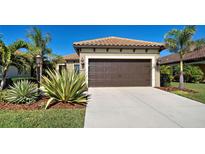 Single-story home with a two-car garage and landscaped front yard at 295 Cassano Drive, Nokomis, FL 34275
