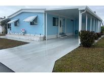 Charming blue single-story home featuring awnings, a covered entrance, and a well-maintained yard at 356 Longwood Dr, Venice, FL 34285