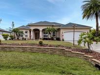 Beautiful one-story home with landscaping, stone wall, and a two-car garage at 4081 Roderigo Ave, North Port, FL 34286