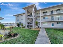 Exterior view of condo building with walkway and landscaping at 649 Tamiami S Trl # 107, Venice, FL 34285