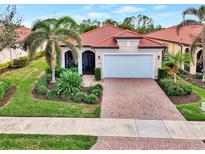 Single-story home with brick driveway and landscaped yard at 10457 Crooked Creek Dr, Venice, FL 34293