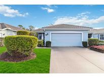 Cute Florida home with light blue exterior, two-car garage, and well-manicured lawn at 1634 Monarch Dr # 1634, Venice, FL 34293