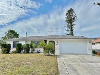 Single-story house with white exterior, gray roof, and a two-car garage at 212 San Carlos Ave, North Port, FL 34287
