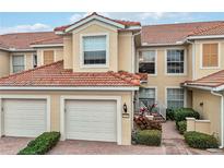 Two-story townhome with two-car garage, and landscaped walkway at 23253 Banbury Way, Venice, FL 34293