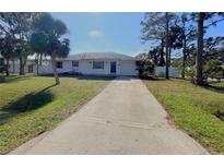 Cute one-story home with a long driveway and palm trees at 3110 Siesta Dr, Venice, FL 34293