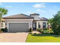 Single-story home with tile roof, attached garage, and landscaped lawn at 4523 Terrazza Ct, Bradenton, FL 34211