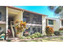 Exterior view of condo showing building, landscaping, and a stairway at 654 Bird Bay E Dr # 206, Venice, FL 34285