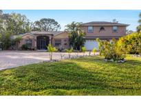Two-story house with a large driveway and landscaped yard at 690 Percheron, Nokomis, FL 34275
