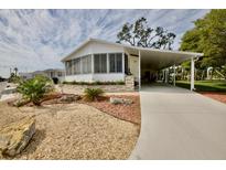 Single-wide home with carport and landscaped yard at 701 S Green Cir, Venice, FL 34285