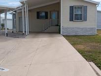 Tan mobile home with carport and paved driveway at 779 N Green Cir, Venice, FL 34285