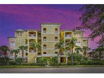Beautiful yellow building exterior with palm trees at 10501 Amberjack Way # 103, Englewood, FL 34224