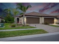 Two-car garage, landscaped yard, and attractive exterior at 12391 Amica Loop, Venice, FL 34293