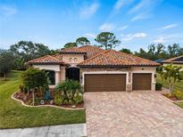 Single-Gathering home with three car garage, paver driveway and lush landscaping at 12950 Basilica Dr, Venice, FL 34293