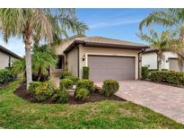 Single-story home with a two-car garage and landscaped front yard at 13836 Alafaya St, Venice, FL 34293