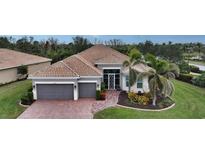 Single-story home with tile roof, gray garage doors, and landscaped yard at 19500 Petrino St, Venice, FL 34293