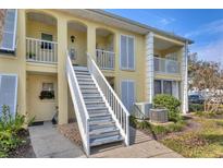 Exterior view of condo building with stairs and landscaping at 402 Cerromar N Cir # 207, Venice, FL 34293