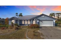 Charming single-story home featuring an attached two-car garage and a well-maintained, landscaped front yard at 7321 Teaberry St, Englewood, FL 34224