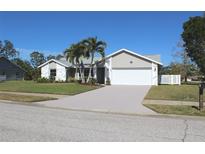 Single-story house with a white garage door and palm trees in the front yard at 104 Woodingham Dr, Venice, FL 34292