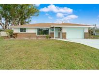 Charming single-story home with a light teal garage door and well-manicured lawn at 313 Hillview Rd, Venice, FL 34293