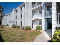 Exterior view of condo building, showing walkway, landscaping, and building facade at 408 Cerromar S Cir # 132, Venice, FL 34293