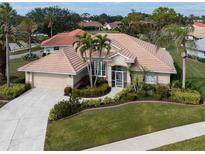 Single-Gathering home with tile roof, landscaping, and driveway at 5045 Whitestone Dr, Venice, FL 34293