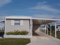 Tan mobile home with carport and landscaping at 516 Ashwood Dr, Venice, FL 34285