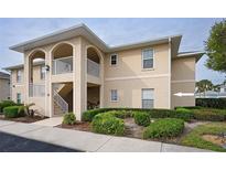 Charming two-story condo featuring stucco siding, arched entryways, and well-maintained landscaping at 5800 Sabal Trace Dr # 701, North Port, FL 34287