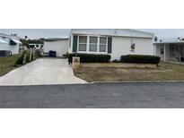 Single-wide manufactured home with carport and landscaped yard at 863 Baveno Dr, Venice, FL 34285