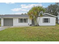 White house with gray accents, attached garage, and landscaping at 1114 Myrtle Ave, Venice, FL 34285